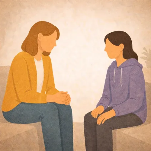 Erwachsene Frau und weibliche Jugendliche blicken sich sitzend an